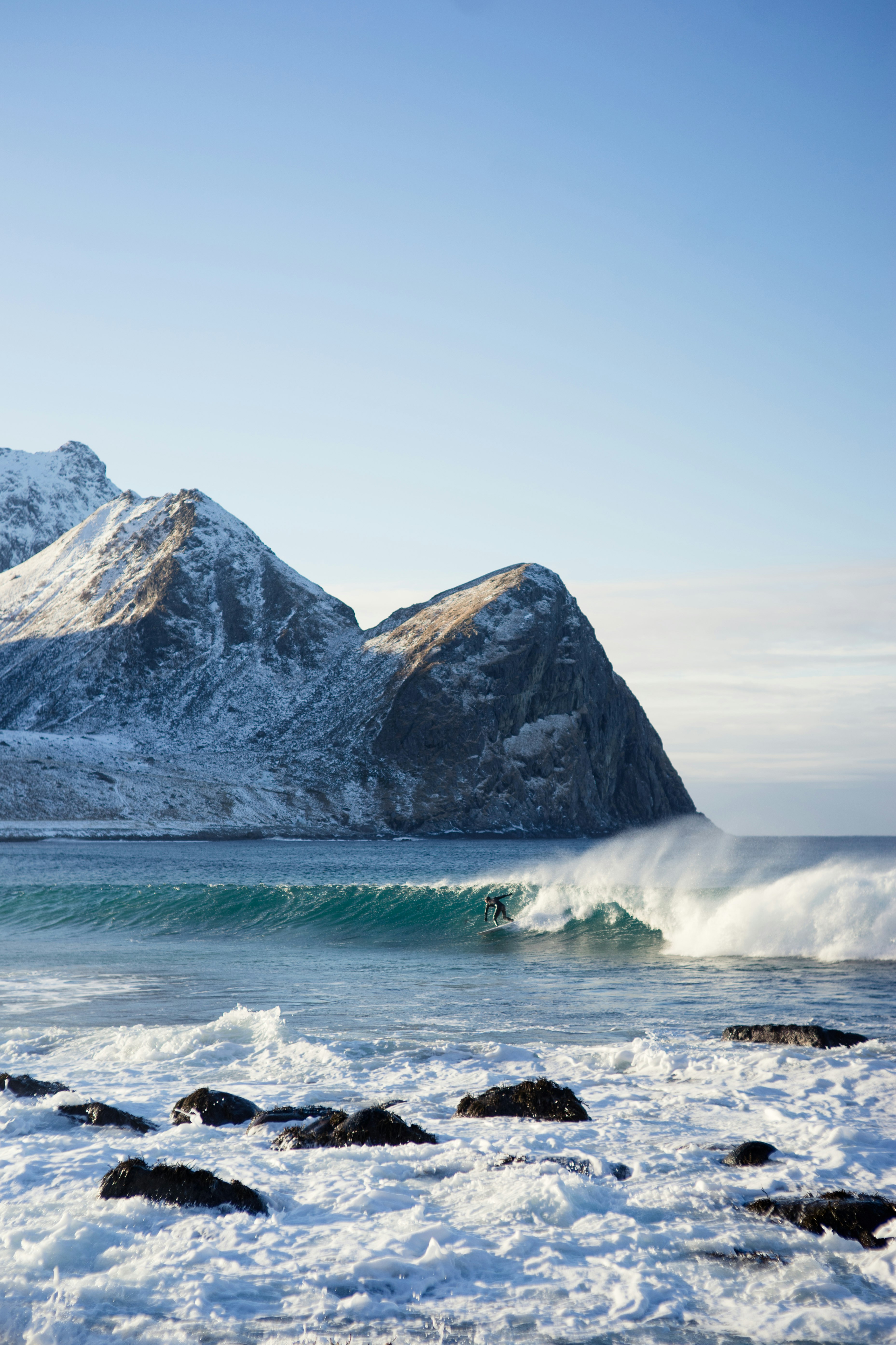 surfer riding body of water wave during daytime